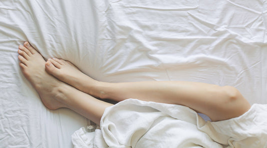 Legs in bed with white sheets