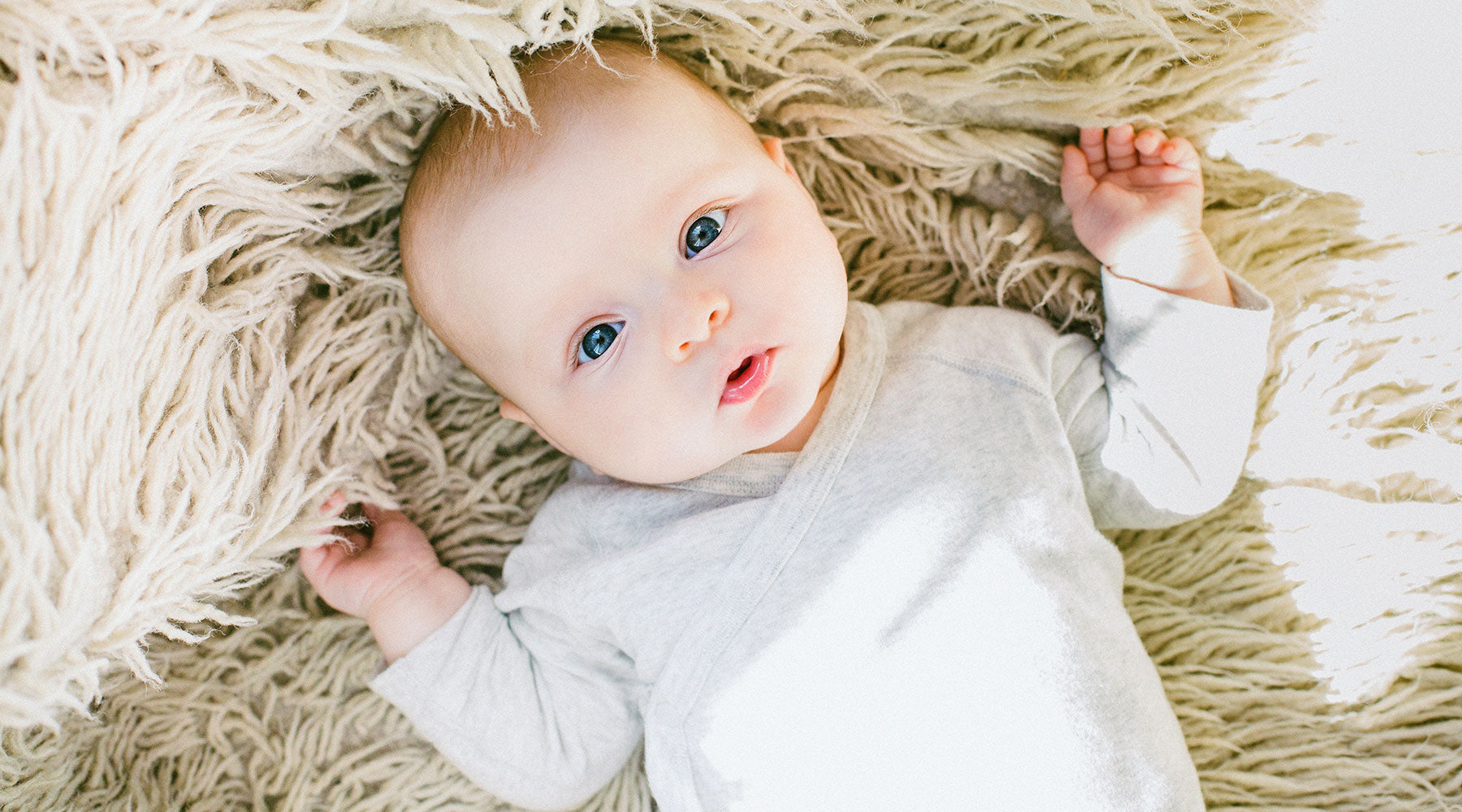 Cute Baby with Blue Eyes on Soft Blanket