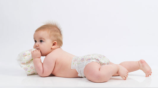 Baby laying on stomach with Happy Little Camper Diapers