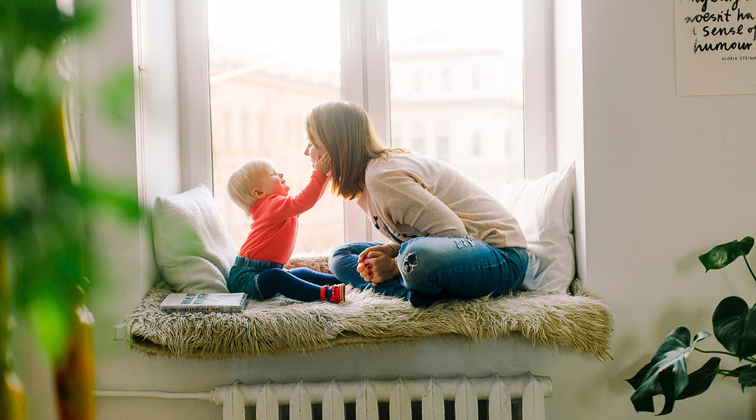 Mom and baby playing by window