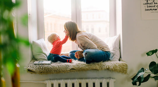 Mom and baby playing by window